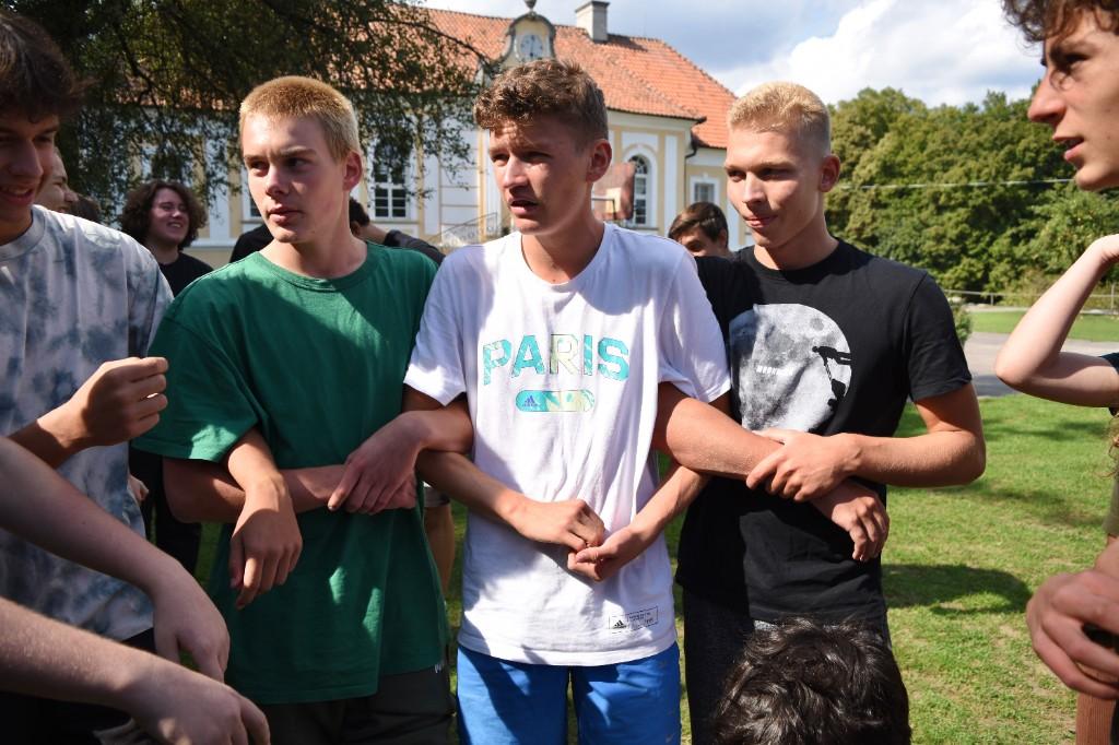 Študenti spolupracujú pri práci s páskou a vetvami v lese